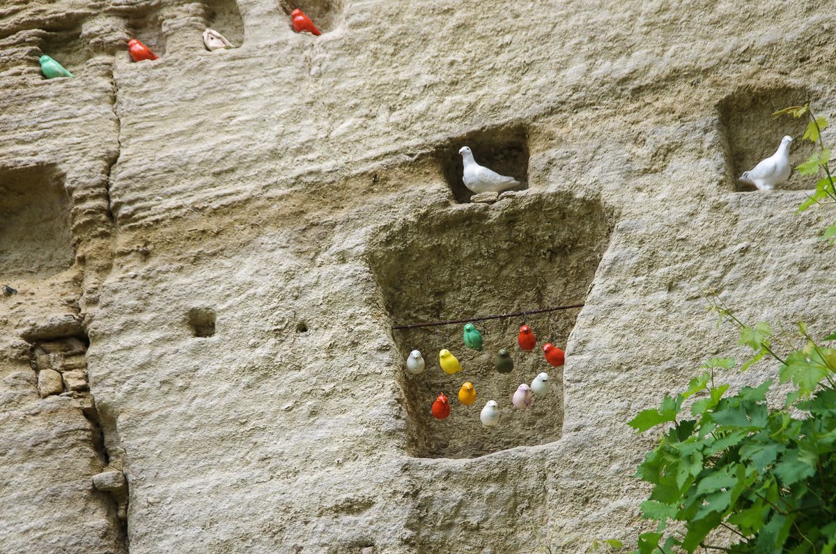 Land art : oiseau céramique dans des niches de pierre à Gordes dans le Luberon