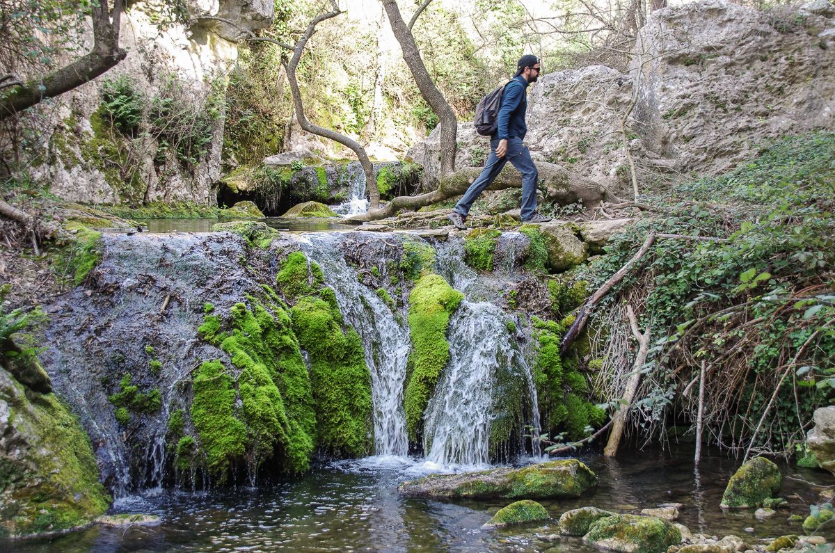 Randonneur dans le Luberon qui traverse une cascade