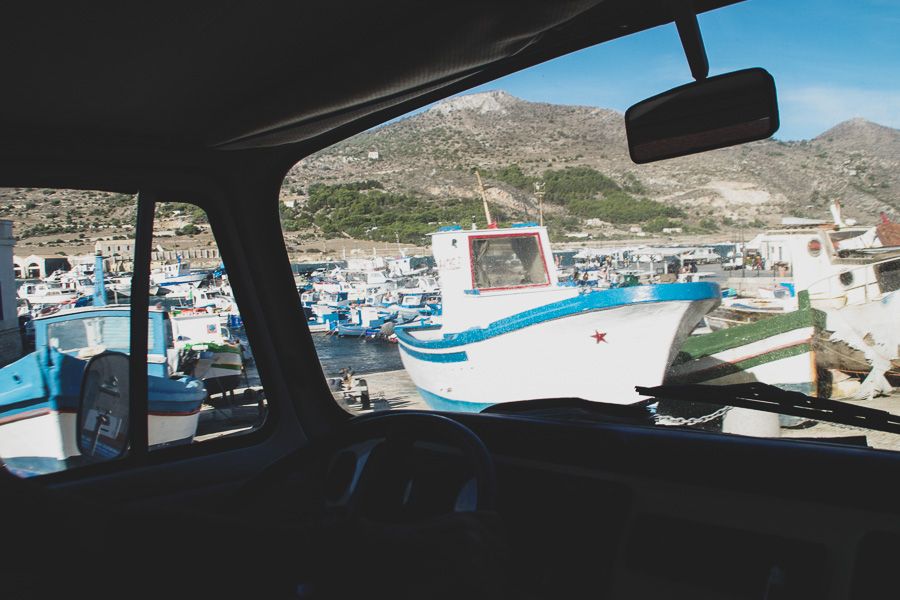 Vue à travers la fenêtre du combi vw sur le port de Favignana